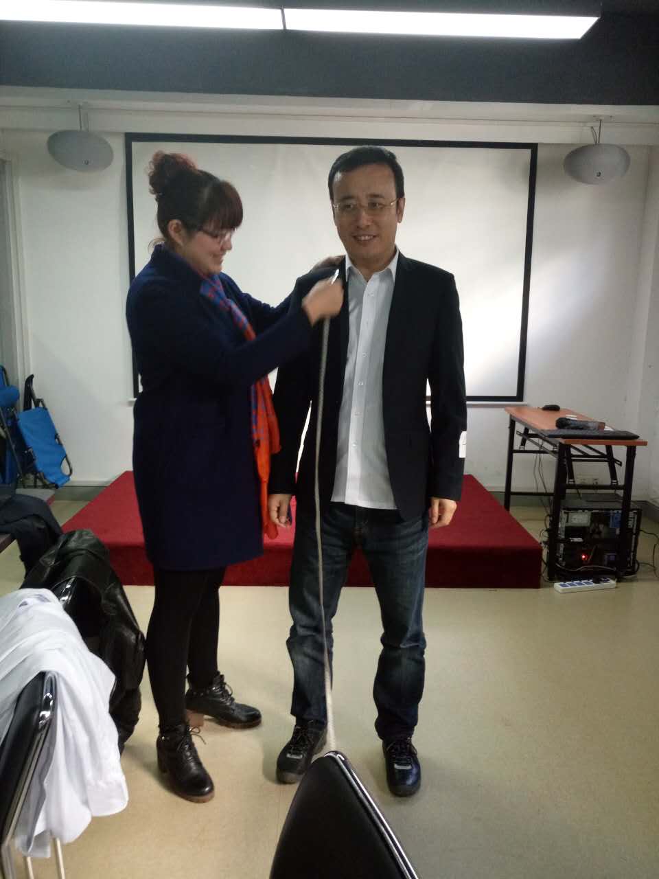 乐好千秋职业装电商部主任李李秀红女士为牛商网总经理袁慧君先生量体